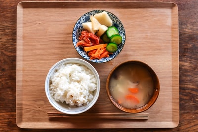 ごはん味噌汁野菜が並べられた食事の画像